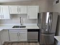 Bright kitchen featuring stainless steel refrigerator and dishwasher, white cabinets, and a modern faucet at 1642 Palma Vista Ave, Las Vegas, NV 89169