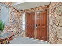 Stone entryway with wooden double doors and a glass block window at 1904 Chapman Dr, Las Vegas, NV 89104