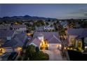 Stunning aerial view of a home showcasing its roofline and the neighborhood at twilight with mountain backdrop at 2287 Moresca Ave, Henderson, NV 89052