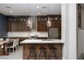 Modern kitchen features custom cabinets, stainless steel appliances, and a breakfast bar with pendant lighting at 2287 Moresca Ave, Henderson, NV 89052