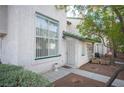Inviting townhome with white stucco, green accents, and a secure gated entrance at 2430 Old Forge Ln # 106, Las Vegas, NV 89121