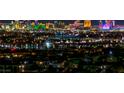 Stunning nighttime view of the vibrant Las Vegas city lights from a high vantage point overlooking residential rooftops at 2824 Soaring Peak Ave, Henderson, NV 89052