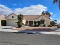 Inviting single-story residence with desert landscaping, a red tile roof, and an attached two-car garage at 3100 Gladstone Ct, Las Vegas, NV 89134