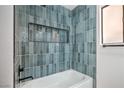 Stylish bathroom with blue vertical tiles, bathtub, and black trim at 3104 Waterview Dr, Las Vegas, NV 89117