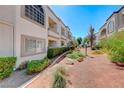 A well-maintained condominium exterior with lush landscaping, red rock and green bushes adding to the curb appeal at 3125 N Buffalo Dr # 1136, Las Vegas, NV 89128