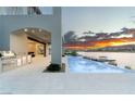 Outdoor kitchen and infinity pool overlooking the lake with mountain views at sunset at 32 Grand Corniche Dr, Henderson, NV 89011