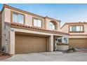 Two-story stucco townhome featuring a two-car garage, terracotta roof, and inviting front entryway at 3331 Cheltenham St, Las Vegas, NV 89129
