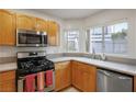 Bright kitchen features stainless steel appliances, light wood cabinets, and a view of the neighborhood at 3331 Cheltenham St, Las Vegas, NV 89129