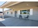 Covered entrance with seating area, view of yard, and decorative wreath on a gray front door at 401 W Lexis Ln, Pahrump, NV 89048