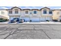 Exterior townhome view showcasing attached garages, and well-maintained landscaping at 4820 Grey Wolf Ln # 101, Las Vegas, NV 89149