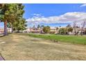 Exterior lawn view showcasing common green space, mature trees, and surrounding residential buildings at 4820 Grey Wolf Ln # 101, Las Vegas, NV 89149