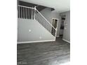 Open-concept living room featuring sleek gray wood floors and staircase with white bannister at 5721 Heineken Dr, North Las Vegas, NV 89031