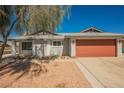 Home with a large, two-car garage door and low-maintenance desert landscaping in the front yard at 6284 Pinewood Ave, Las Vegas, NV 89103