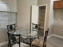 A cozy breakfast nook with a glass table and comfortable seating arrangement next to a window and pantry at 6420 Emerson St, Pahrump, NV 89048