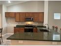 A kitchen showcasing wood cabinets, an oven, a microwave, and plenty of counter space for meal preparation at 6420 Emerson St, Pahrump, NV 89048