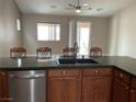 A view of the kitchen sink, faucet, stainless steel dishwasher, and chairs along the kitchen island at 6420 Emerson St, Pahrump, NV 89048