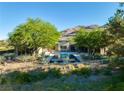 Back exterior view of a luxury home with a pool, patio, and mountain views at 66 Golf Estates Dr, Las Vegas, NV 89141