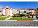 Well-maintained two-story condo building with manicured lawn and greenery at 737 Oakmont Ave # 1202, Las Vegas, NV 89109