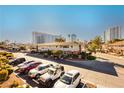 Condominium exterior with parking and view of the city skyline under a clear, blue sky at 737 Oakmont Ave # 1202, Las Vegas, NV 89109