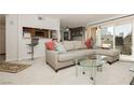 Comfortable living room with a gray sectional couch, glass table and balcony at 737 Oakmont Ave # 1202, Las Vegas, NV 89109