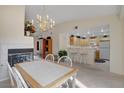 Open dining area with a modern chandelier, fireplace, and breakfast bar leading to the kitchen with plenty of light at 908 Domnus Ln # 203, Las Vegas, NV 89144