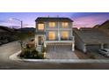 Elegant two-story home with a balcony, three-car garage, and inviting curb appeal at dusk at 9783 Hawk Crest St, Las Vegas, NV 89141