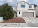 Two-story home featuring a two-car garage, stucco exterior, and desert landscaping at 1844 Navajo Lake Way, Las Vegas, NV 89128