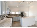 Kitchen features mosaic backsplash, breakfast bar, stainless steel appliances, and light blue cabinets at 2128 La Salle St, Las Vegas, NV 89106