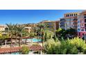 Aerial view of condos and pool area featuring mature palms and green landscape at 30 Strada Di Villaggio # 118, Henderson, NV 89011