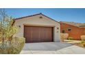 Single-story home with a tile roof and a two-car garage, showcasing its clean and simple design at 3649 Starlight Ranch Ave, North Las Vegas, NV 89081