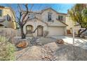 Inviting two-story home featuring desert landscaping, a spacious driveway, and an attached garage at 4225 Ponce Royal Ave, North Las Vegas, NV 89031