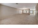 Expansive living room with neutral carpet and walls, complemented by natural light from large windows at 4225 Ponce Royal Ave, North Las Vegas, NV 89031