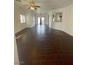 Spacious living room featuring dark hardwood floors and natural light from large windows at 4236 Thomas Patrick Ave, North Las Vegas, NV 89032