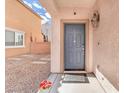 Welcoming entryway featuring a stylish gray front door, lantern sconce, and a decorative welcome mat at 5351 Glenburnie St, Las Vegas, NV 89122