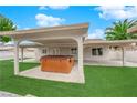 Inviting backyard with a covered patio, a hot tub, and artificial grass at 57 Marion Dr, Las Vegas, NV 89110