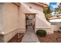 Inviting entryway featuring an arched opening and desert landscaping at 8112 Broken Spur Ln, Las Vegas, NV 89131