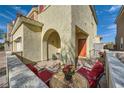 Inviting front porch with red cushioned chairs and a beautiful mosaic table at 996 Cetona Ct, Henderson, NV 89011