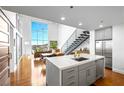 A kitchen and living area featuring an island with a sink, stainless steel appliances, and lots of natural light at 11441 Allerton Park Dr # 212, Las Vegas, NV 89135