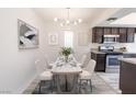 Bright dining area with a modern chandelier, seating for six, and dark wood cabinetry at 1405 Vegas Valley Dr # 247, Las Vegas, NV 89169