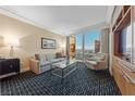 Comfortable living room featuring a sofa, accent chair, glass coffee table, and a city view at 2000 N Fashion Show Dr # 3307, Las Vegas, NV 89109