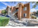 Attractive condominium complex with stucco exterior, tiled roof, and lush landscaping at 2120 Ramrod Ave # 1318, Henderson, NV 89014