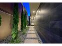 Modern walkway with stone pavers, lush greenery, and accent lighting leading to the home's entrance at 2819 Queens Courtyard Dr, Las Vegas, NV 89109