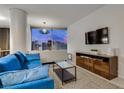 Comfortable living room with a blue sofa, a modern media center, and city views at 3726 Las Vegas Blvd # 2407, Las Vegas, NV 89158