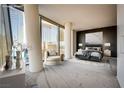 Comfortable bedroom featuring city views, a chair, modern lighting, and a calming color palette at 3726 Las Vegas Blvd # 2506, Las Vegas, NV 89158