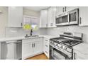 Modern kitchen showcasing white cabinets, stainless steel appliances, and sleek countertops at 451 Concord Way, Henderson, NV 89015