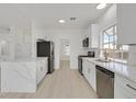 Modern kitchen featuring new stainless steel appliances, marble countertops, and white cabinets at 457 Leighann Rd, Henderson, NV 89015