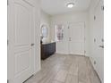 Bright entryway with stylish tile flooring, a modern console table, and a round mirror at 460 Accelerando Way, Henderson, NV 89011