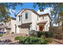 Charming two-story stucco home with a red tile roof, lush landscaping, and a two-car garage at 460 Accelerando Way, Henderson, NV 89011