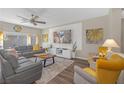 Bright living room with modern decor, laminate floors, large windows, and ceiling fan at 7177 W Camero Ave, Las Vegas, NV 89113