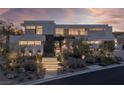 Striking contemporary home with illuminated landscaping, modern design, and inviting entrance at 9 Boulderback Dr, Henderson, NV 89012